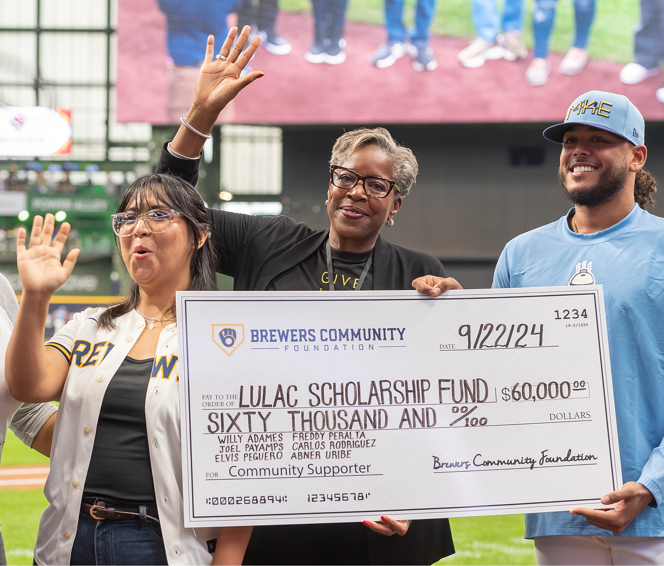 Freddy Peralta (right) with BCF Executive Director Cecelia Gore (center). (Brewers)