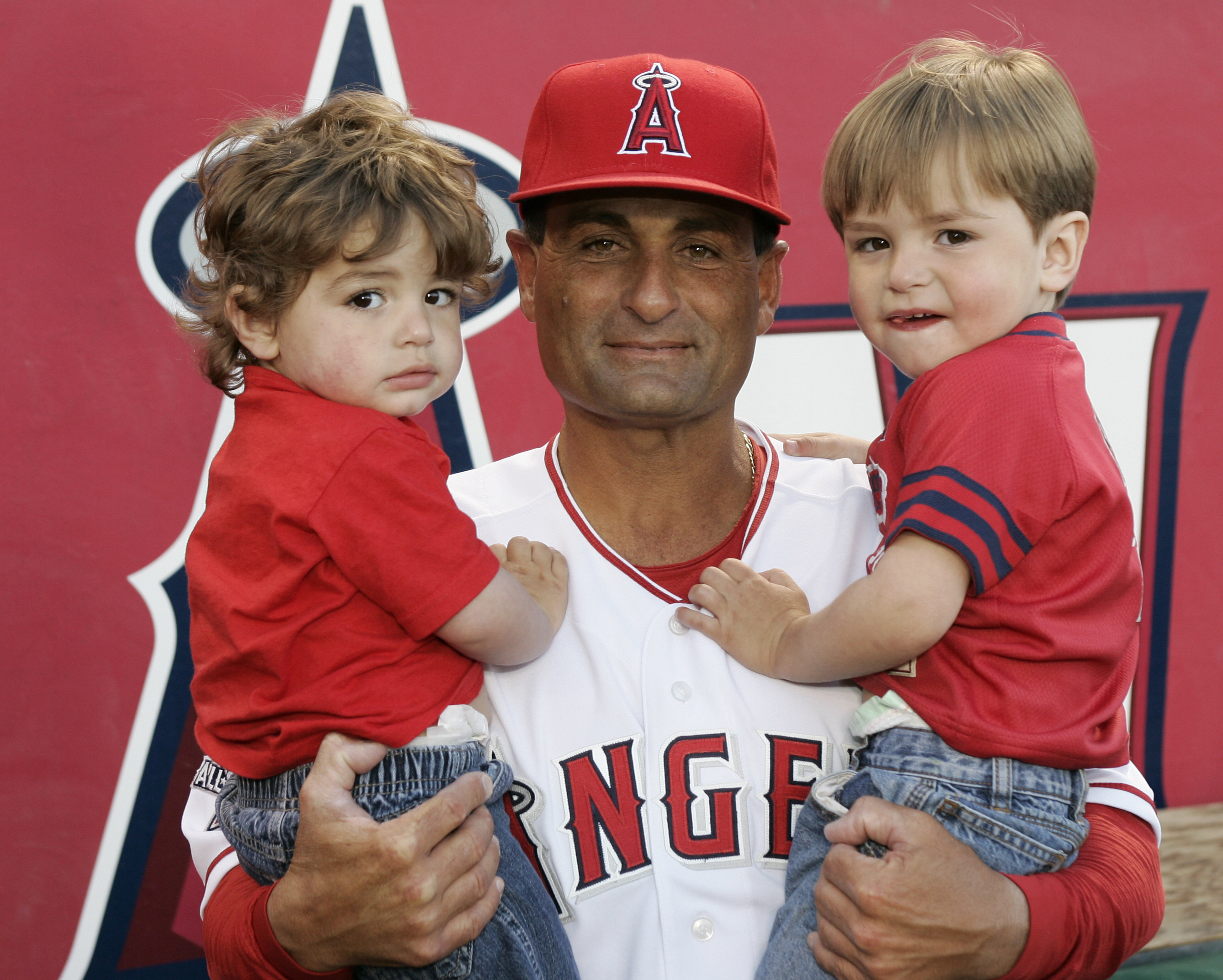 Dino Ebel holds his two sons, Trey and Brady (right).