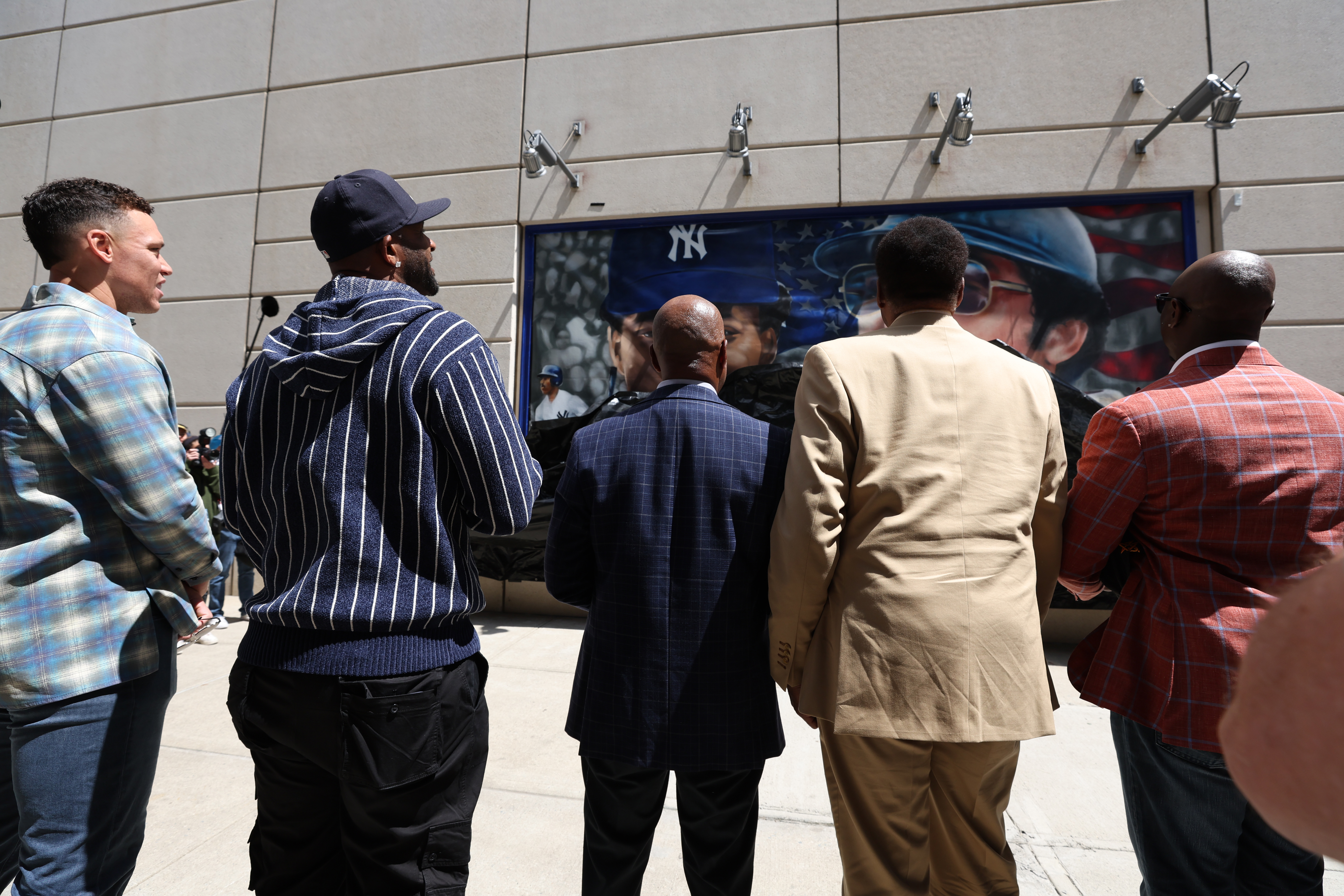 Aaron Judge, CC Sabathia, Willie Randolph, Dave Winfield and Mike Cameron looking at one of the murals.