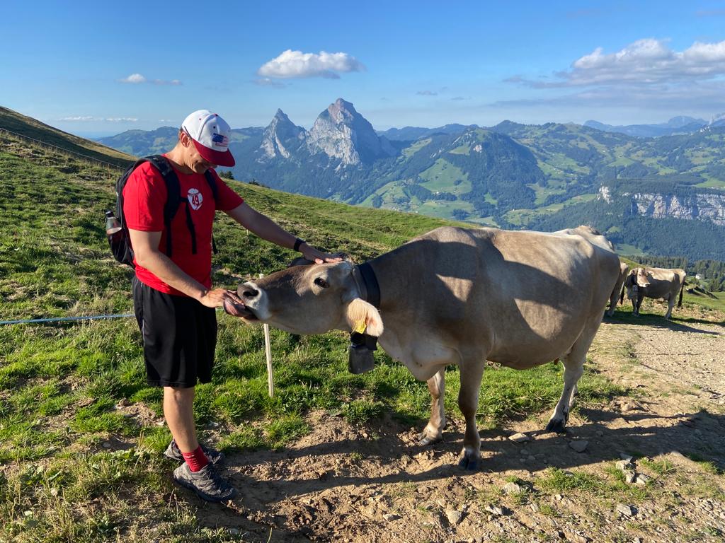 Captain Josh Crouse, in his No. 49 T-shirt, feeds a cow up in the mountains.