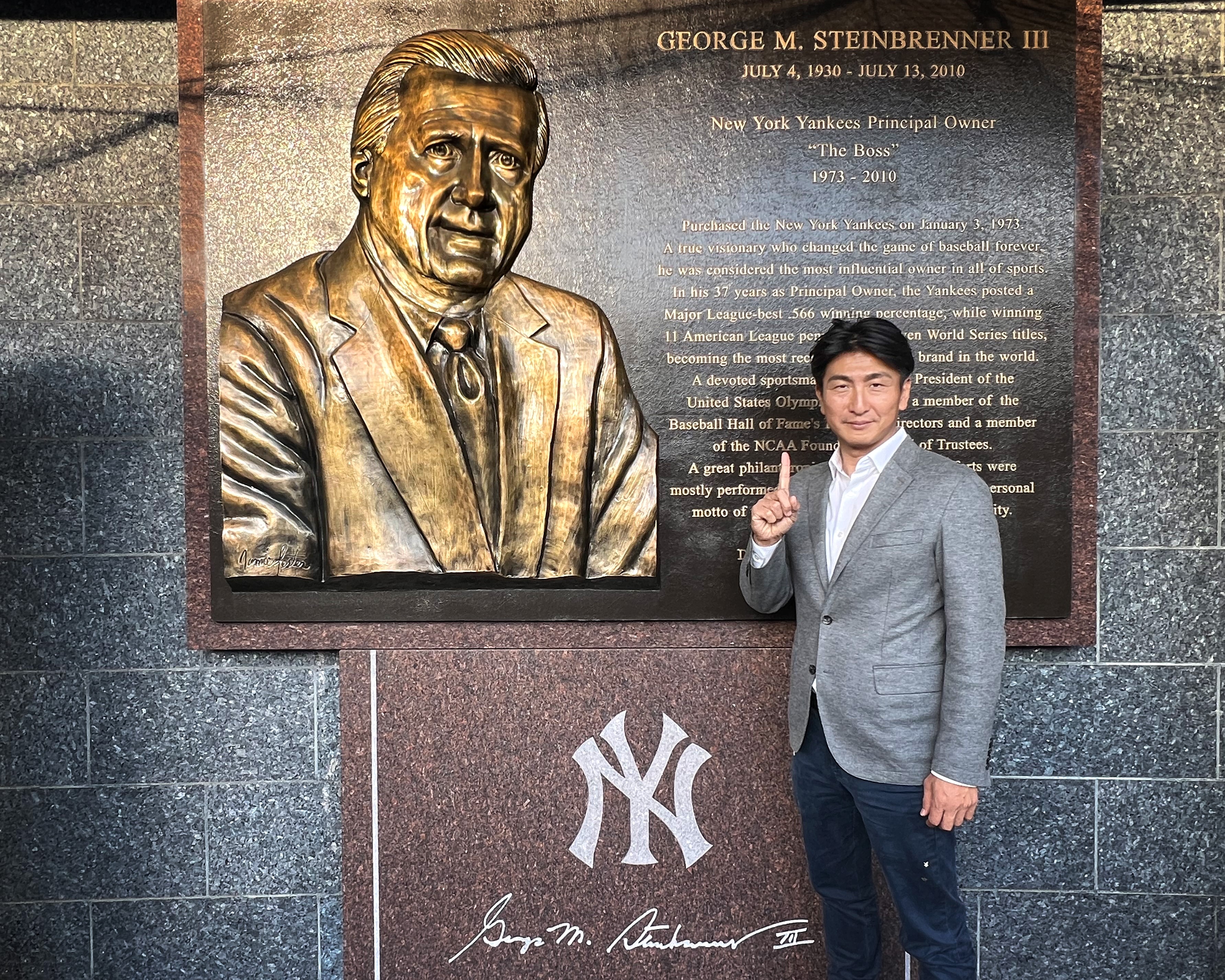 Soichiro Minami poses with the George Steinbrenner plaque at Yankee Stadium (courtesy of Minami)
