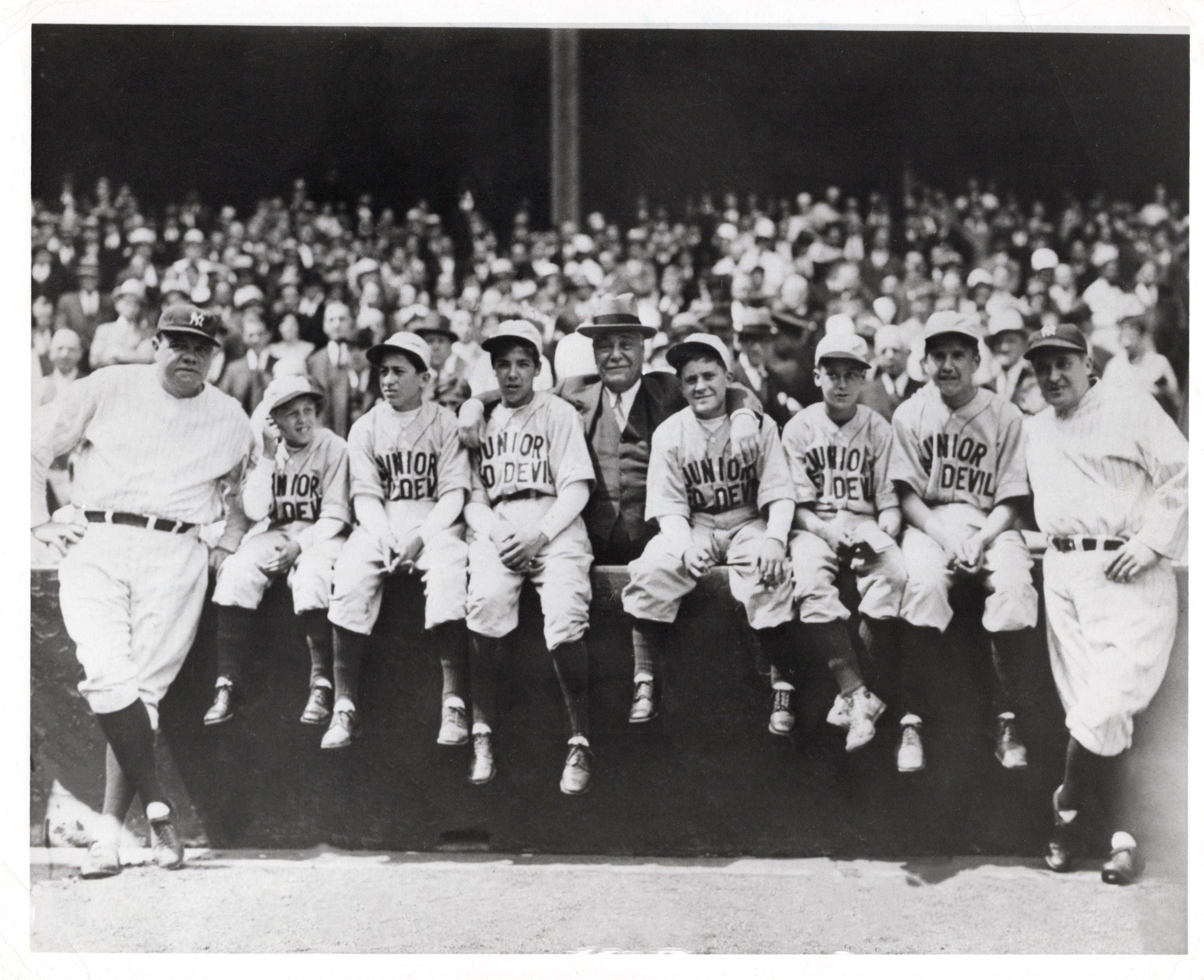 Babe Ruth, Col. Jacob Ruppert and Yankees manager Joe McCarthy pose with the six Passaic orphans at Yankee Stadium on May 20, 1933.