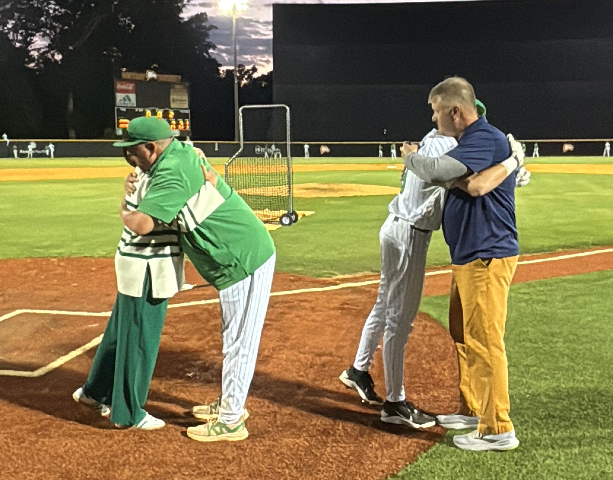 Coach Hamilton Bennett embraces Angie McGee, and Parker hugs his father (Photo by Anthony Castrovince)