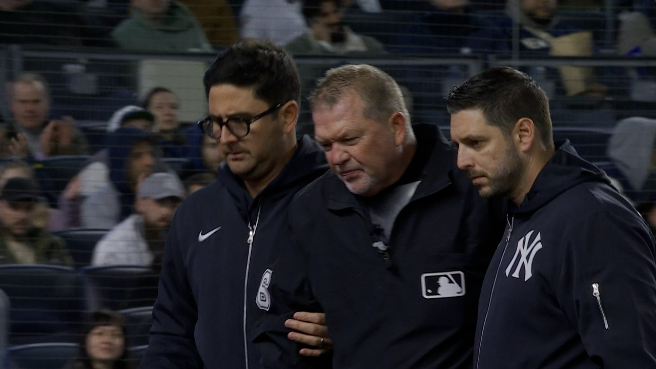 Umpire Ron Kulpa saliendo del juego Yankees vs. Marlins tras recibir un pelotazo de foul en la careta