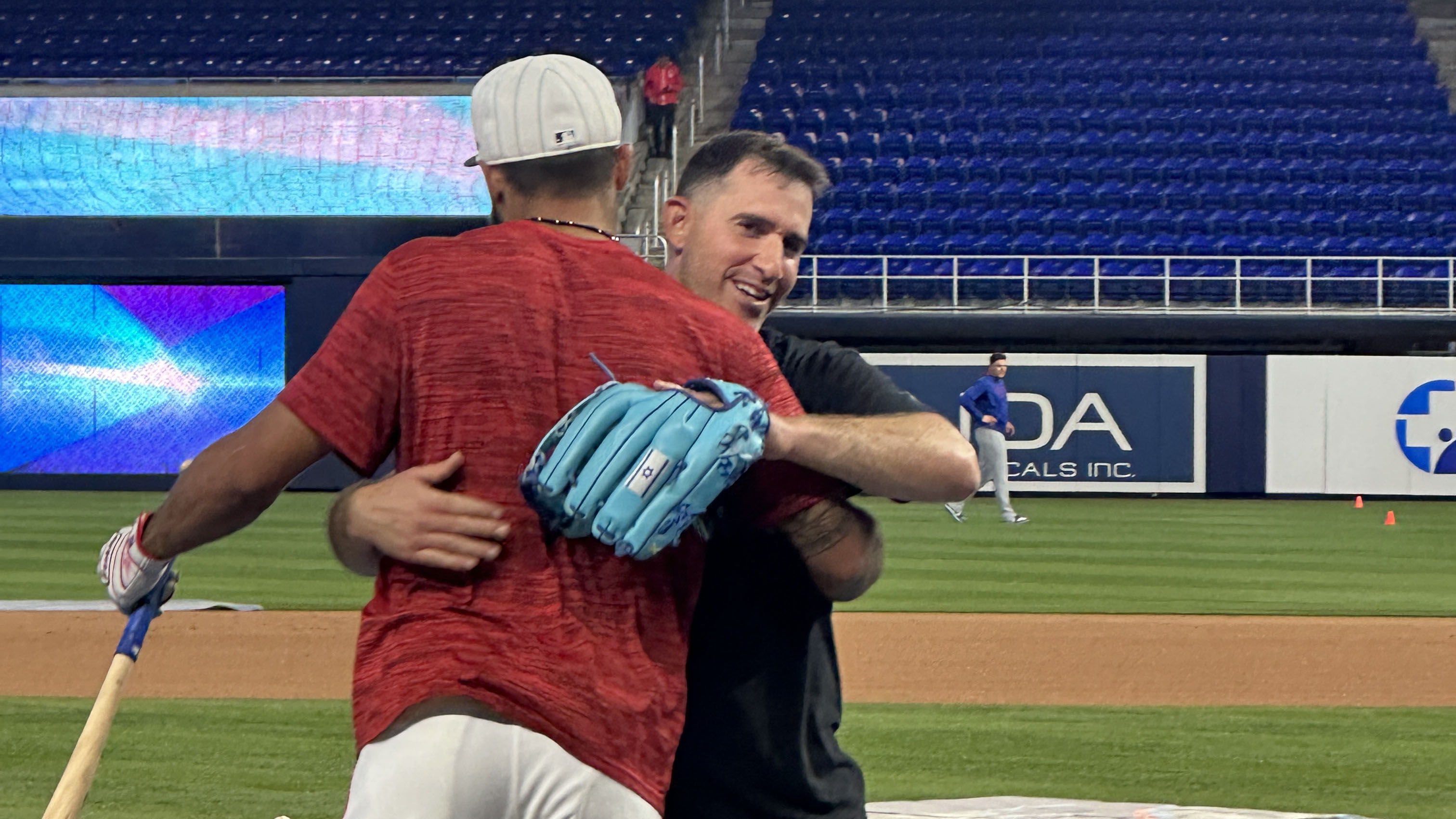 Derek Hill and assistant pitching coach Alon Leichman embrace after the BP competition.