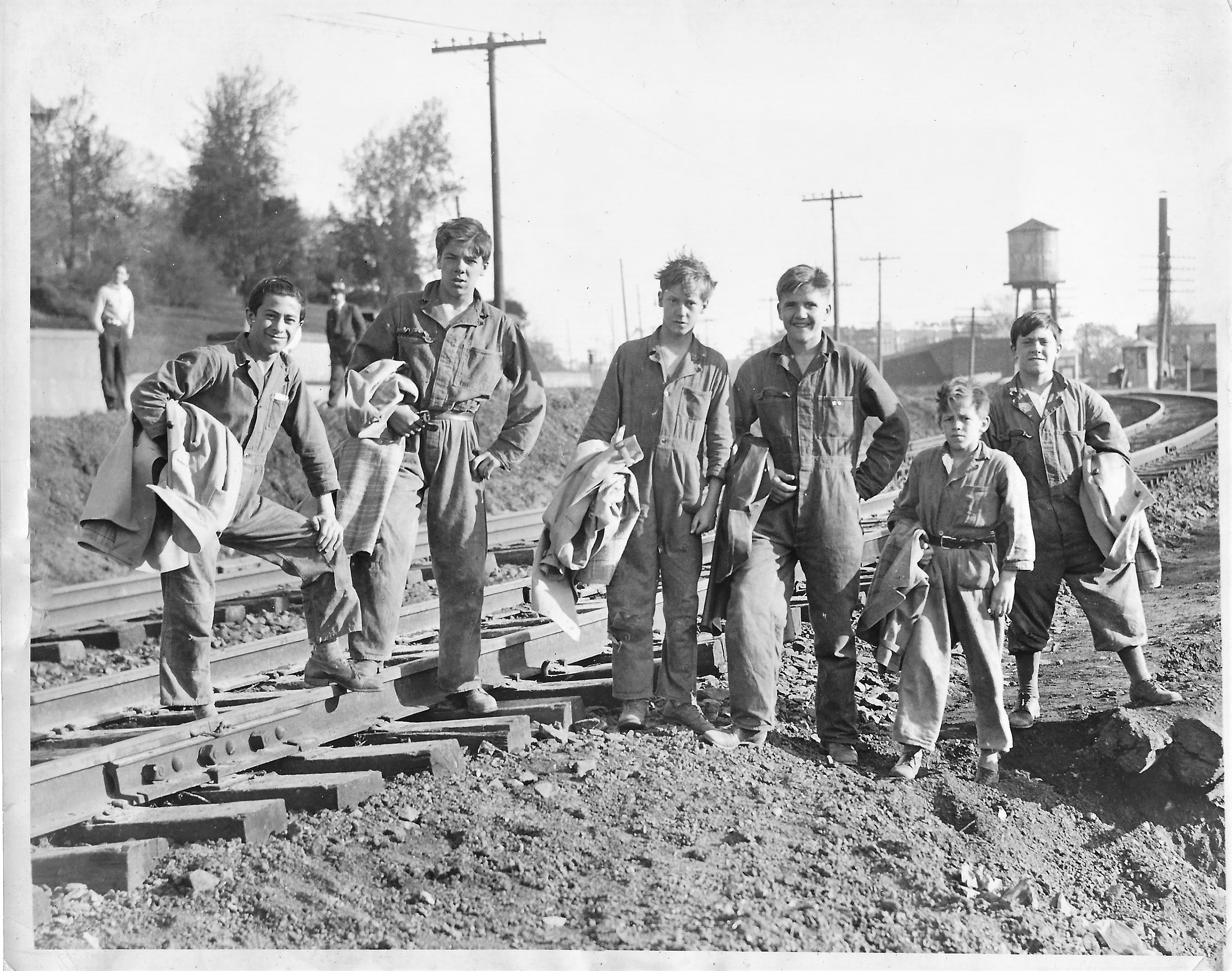 The six Passaic heroes stand near the refurbished tracks in May 1933, holding the raincoats they waved to stop the train. Left to right: Frank Mazzola, Jake Melnizek, Douglas Fleming, Rudolph Borshe, John Murdock and Mike Mazzola.