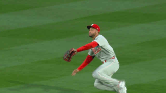 An animated gif of Justin Crawford barely holding on to the ball with a sliding catch