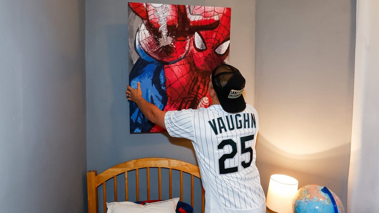 Andrew Vaughn hangs artwork in a child's room