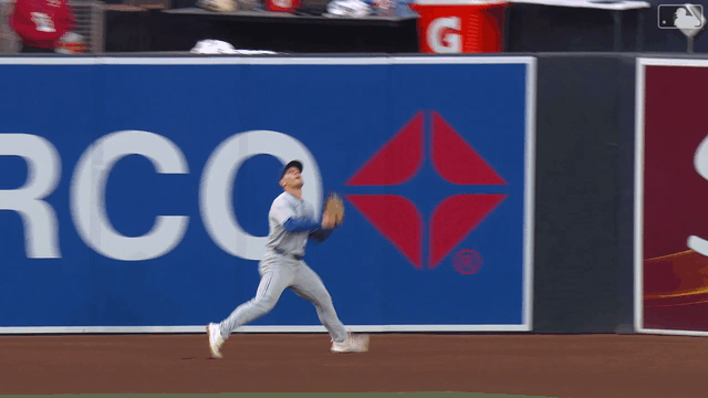 Daulton Varsho makes a leaping catch just before crashing into the wall