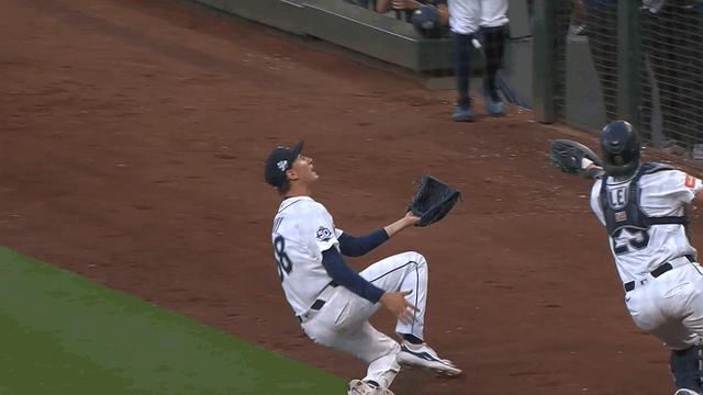 An animated gif of Cal Raleigh making a sliding catch in foul territory
