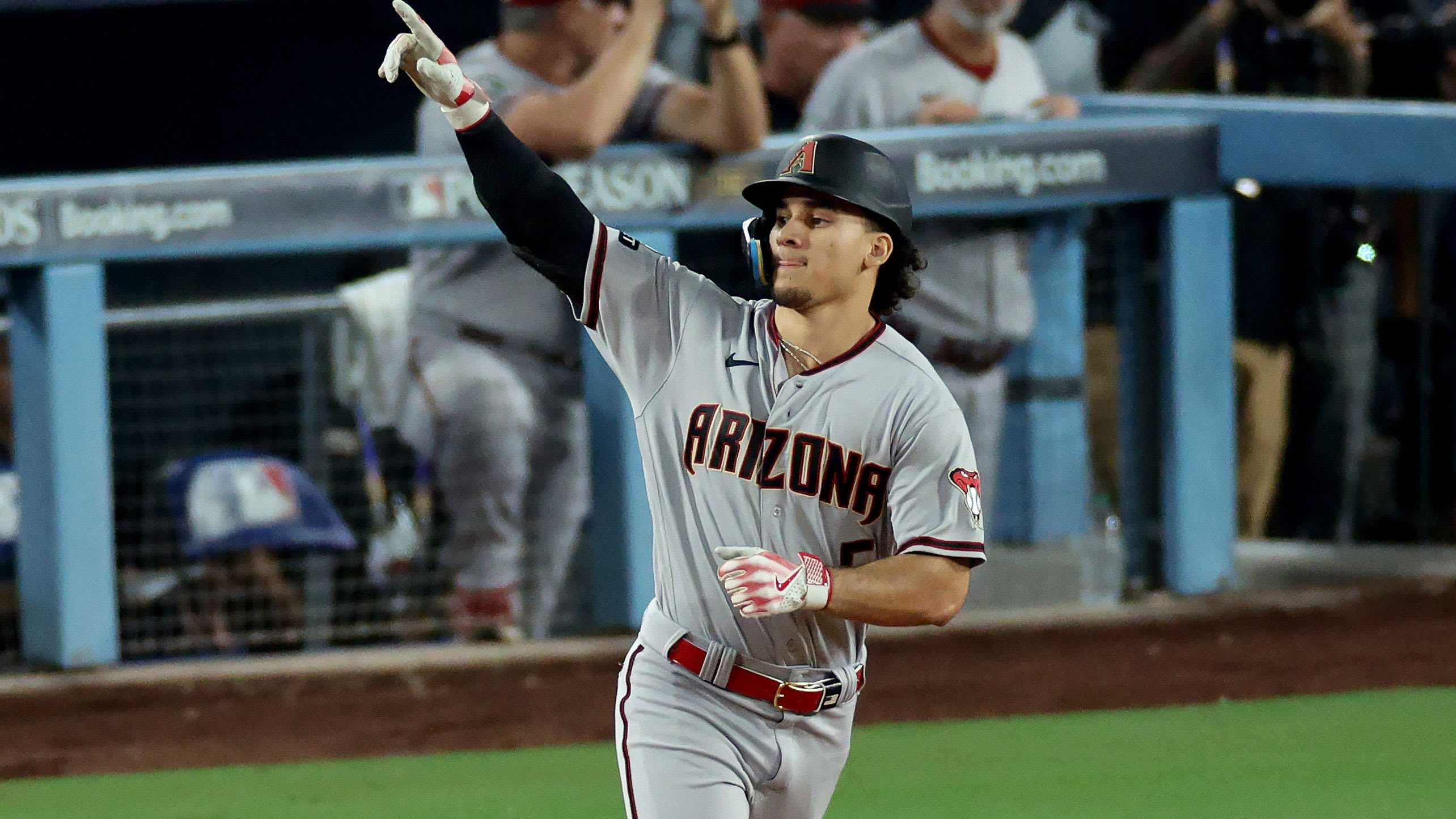 Alek Thomas points as he rounds the bases following his home run