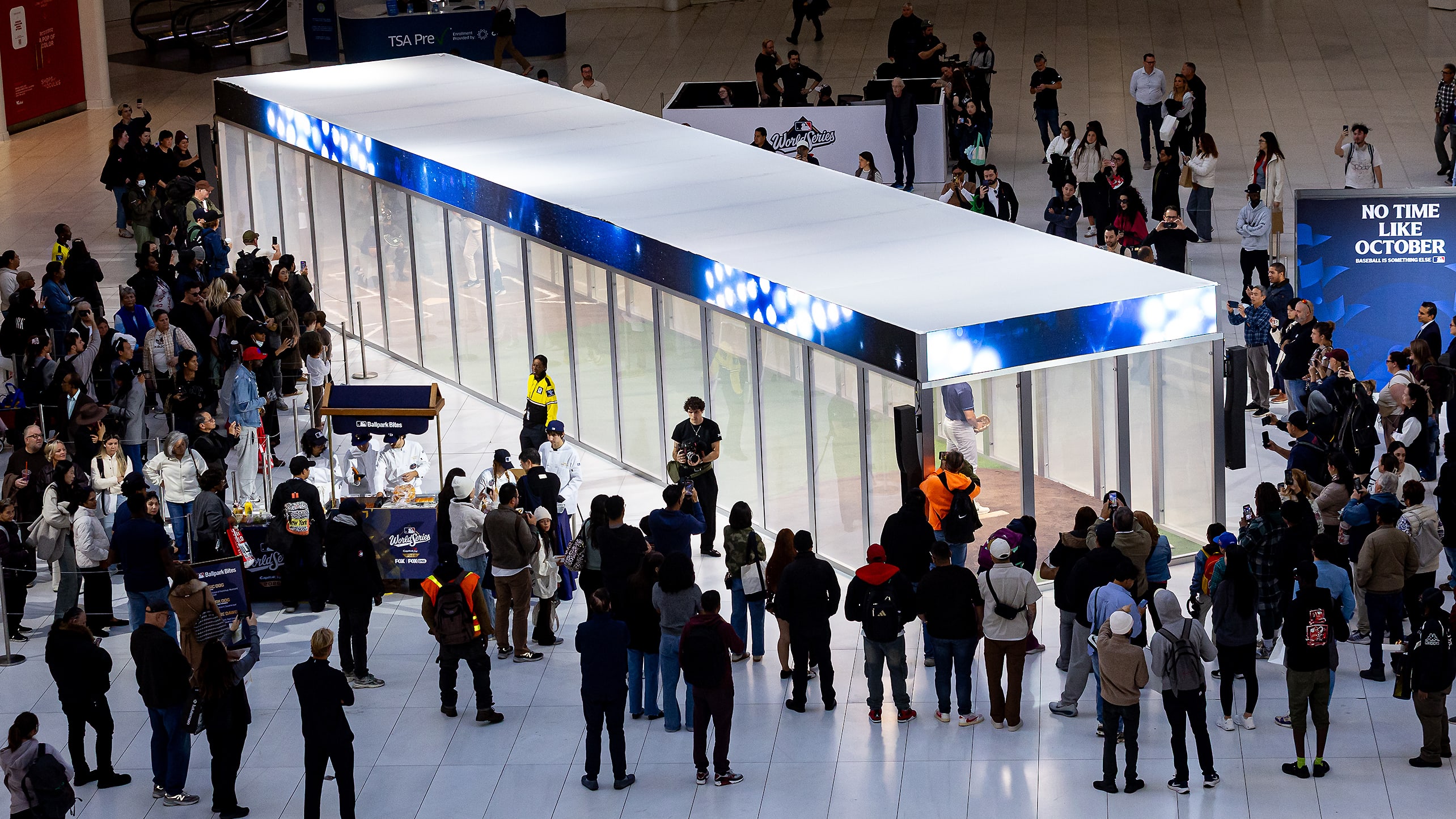 Fans gather around a 65-foot glass box with home plate and a pitcher's mound inside