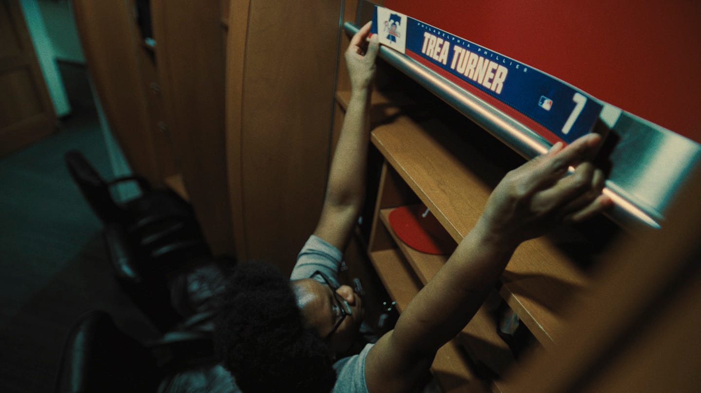 A person places Trea Turner's nameplate above his locker in the clubhouse