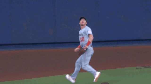 An animated gif of Jacob Young climbing the outfield wall to make a catch