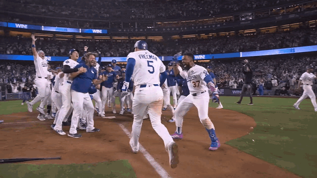 An animated gif of Freddie Freeman and the Dodgers celebrating at home plate