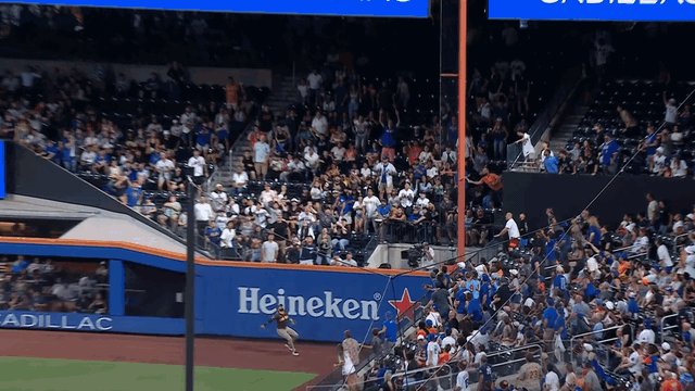 An animated gif of Fernando Tatis Jr. robbing a home run and flipping the ball from his glove to his bare hand