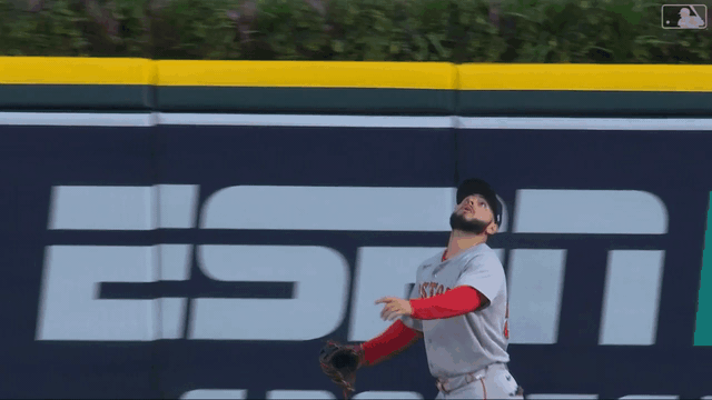An animated gif of Wilyer Abreu leaping at the wall, the ball hitting his glove and deflecting to Ceddanne Rafaela
