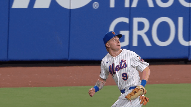 An animated gif of A.J. Ewing twisting around to make a catch in deep center field