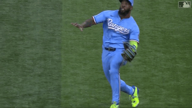 An animated gif of Adolis García making a barehanded grab after the ball bounced off his glove and body