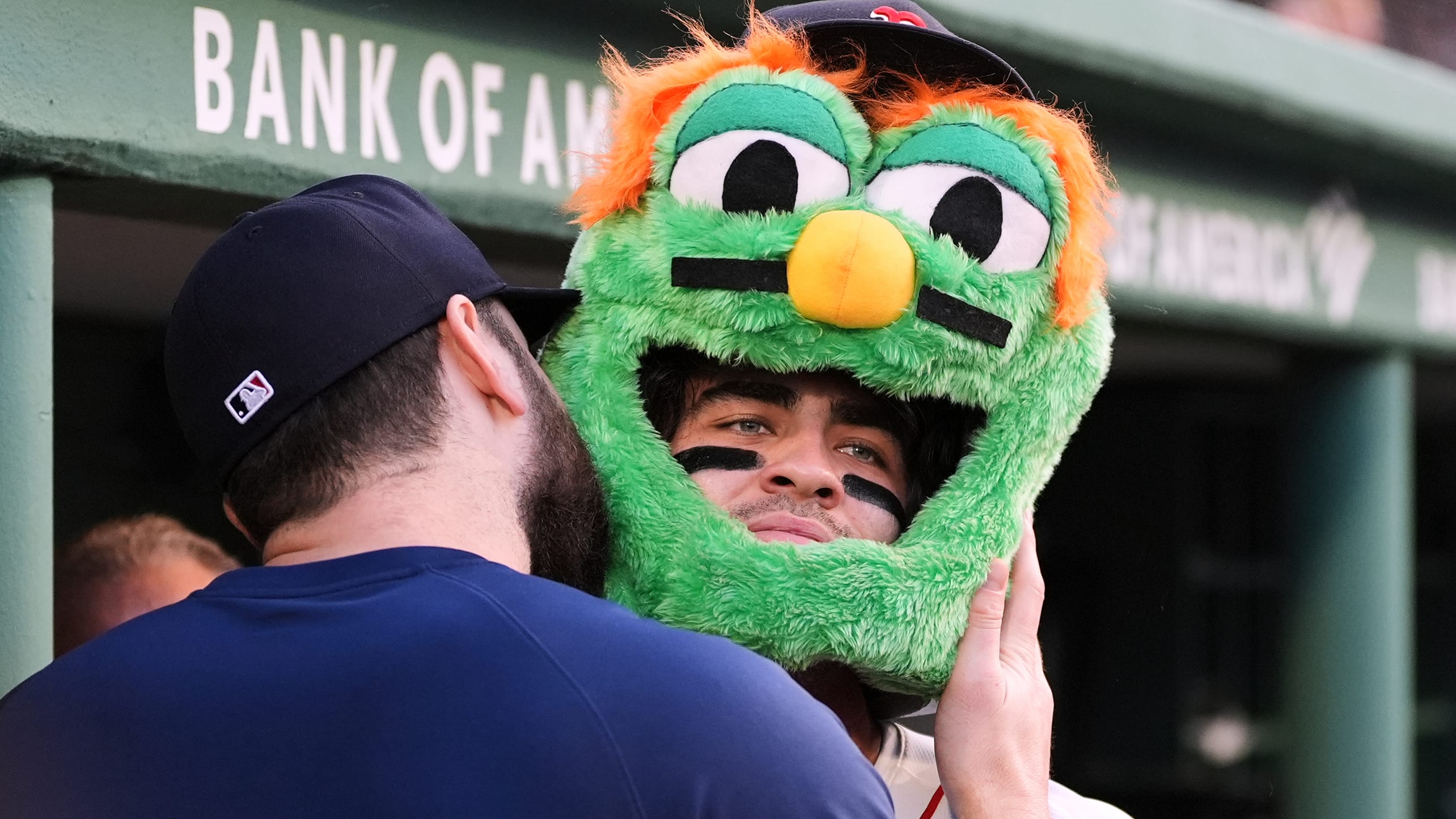 Wearing a Wally mascot head, Marcelo Mayer gets a kiss on the (mascot) cheek from a teammate