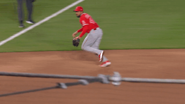 An animated gif of Jeimer Candelario fielding a ground ball on the third-base line and making a strong throw from foul territory