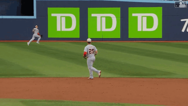 An animated gif of Javier Báez making a diving catch in center field and throwing to first for a double play