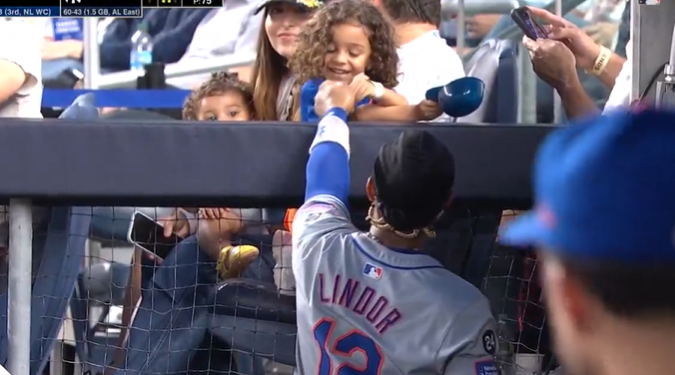 Francisco Lindor gives one of his daughters some gum from the dugout