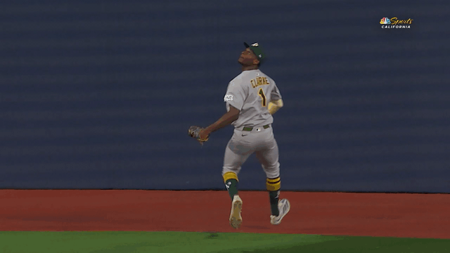 An animated gif of Denzel Clarke climbing the wall to rob a home run