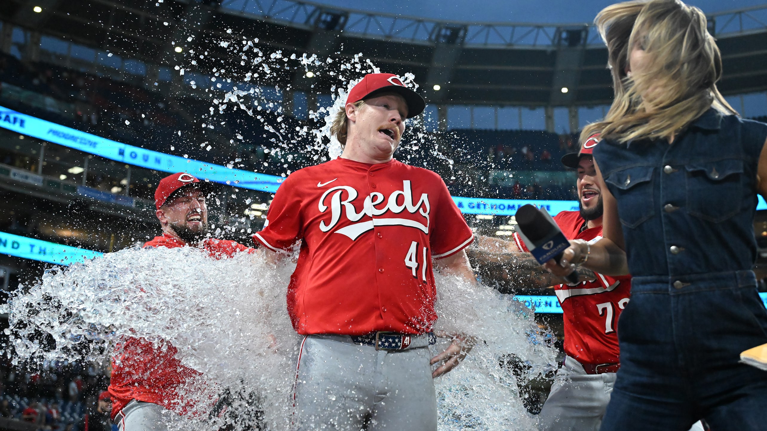 Reds pitcher Andrew Abbott is doused by two teammates during a postgame interview