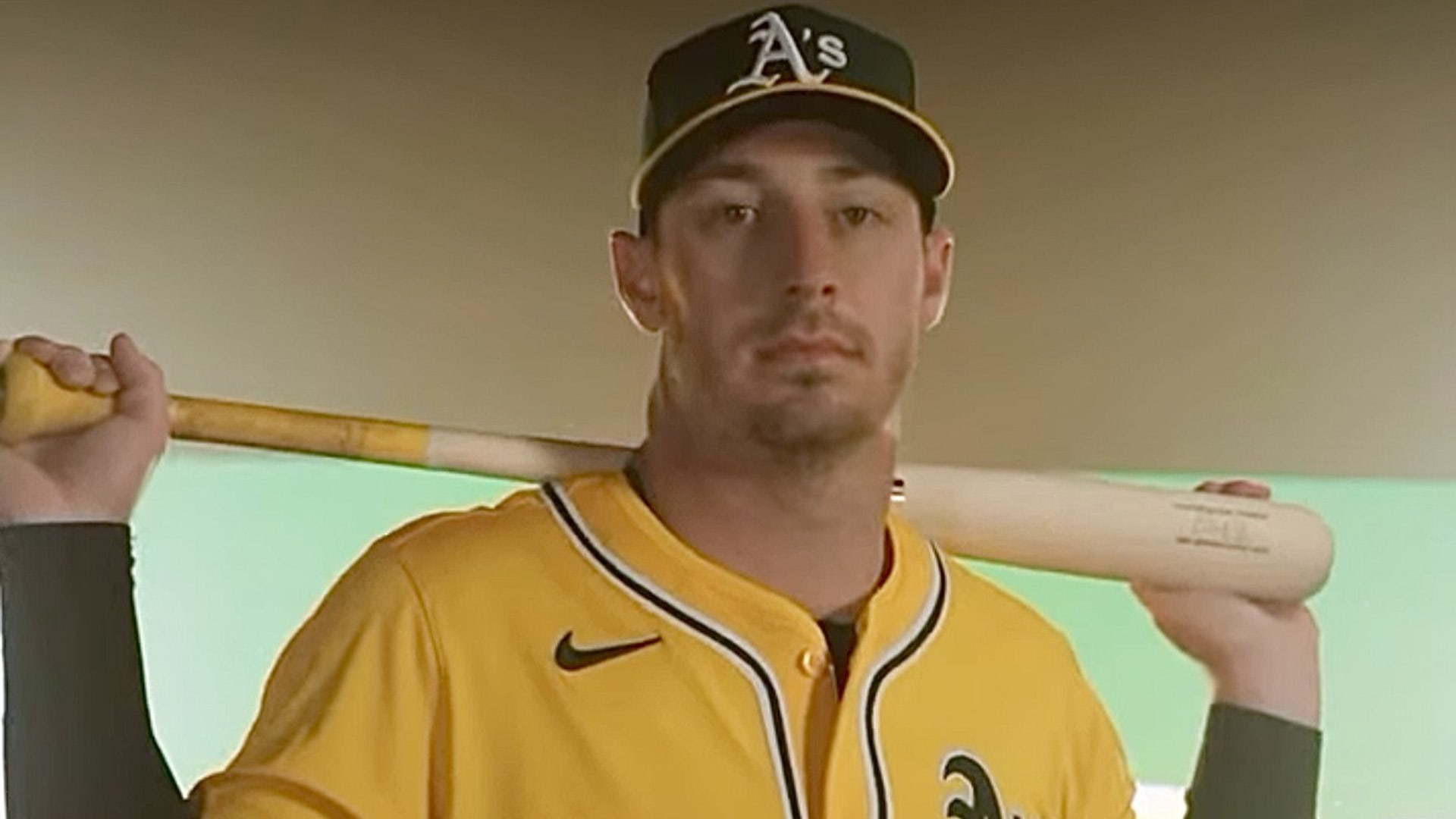 Brent Rooker shows off the A's alternate gold jersey