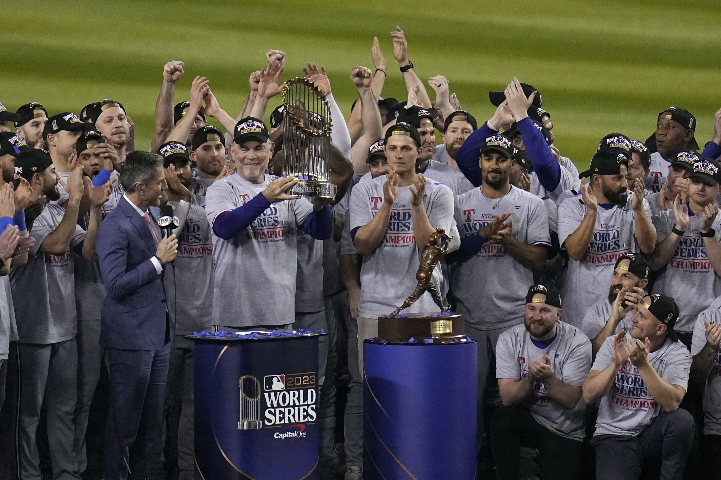 Bruce Bochy holds up the World Series trophy on the postgame stage