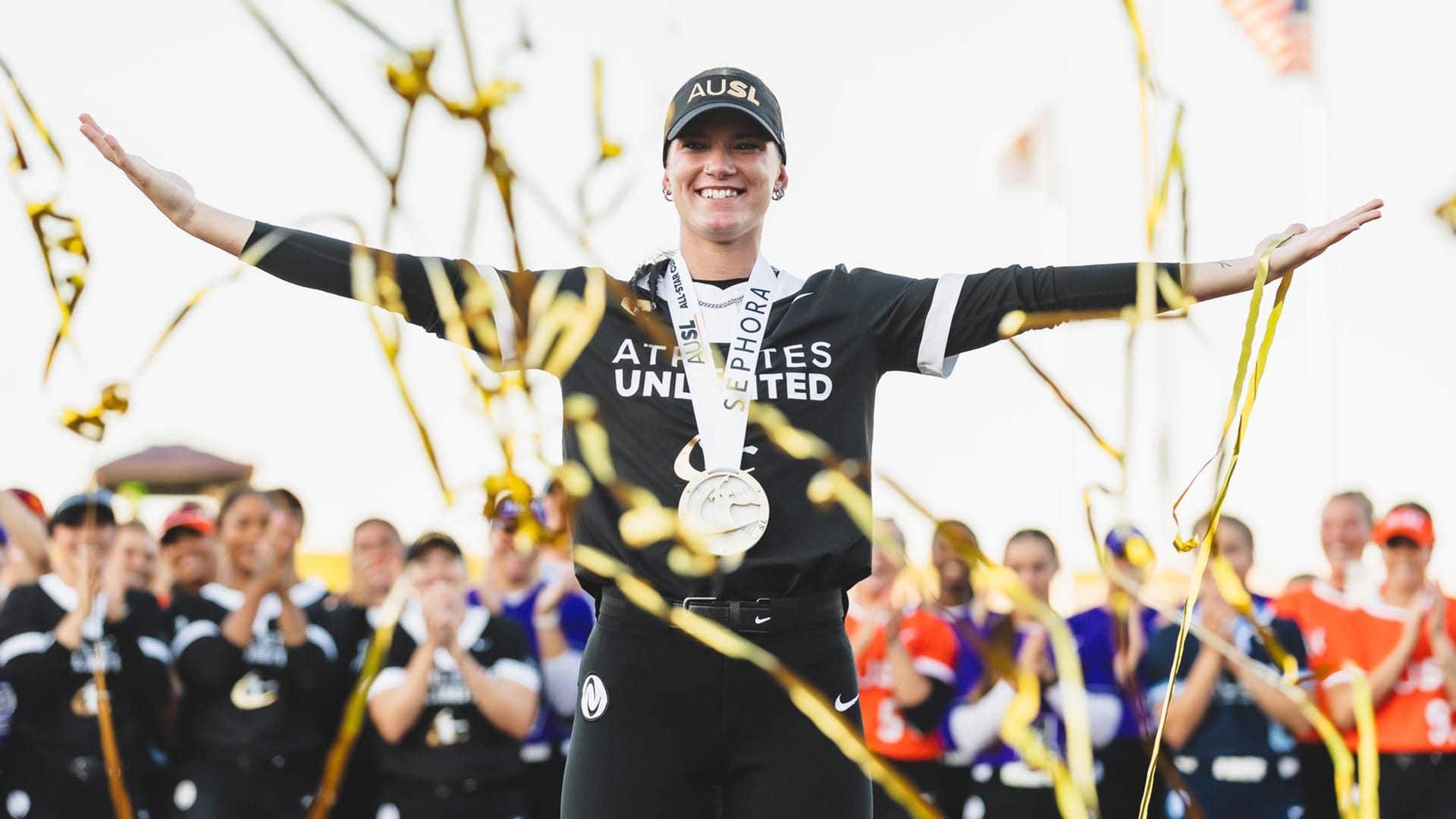 Kayla Kowalik shows off her medal amid streamers falling from above