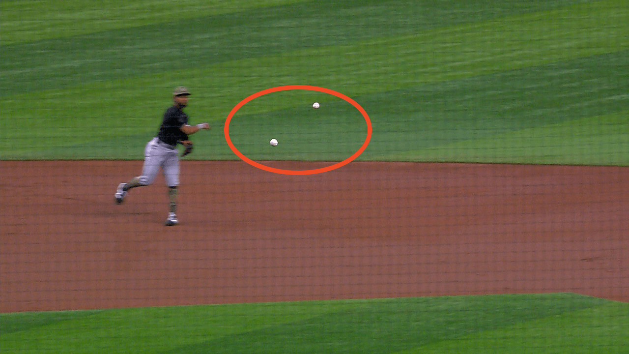 A screenshot of a shortstop with two baseballs in the air near him circled in red