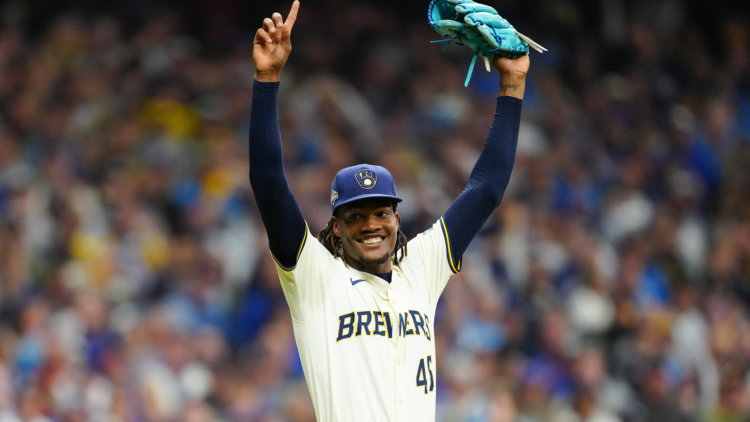 Abner Uribe raises his arms and smiles after getting the last out