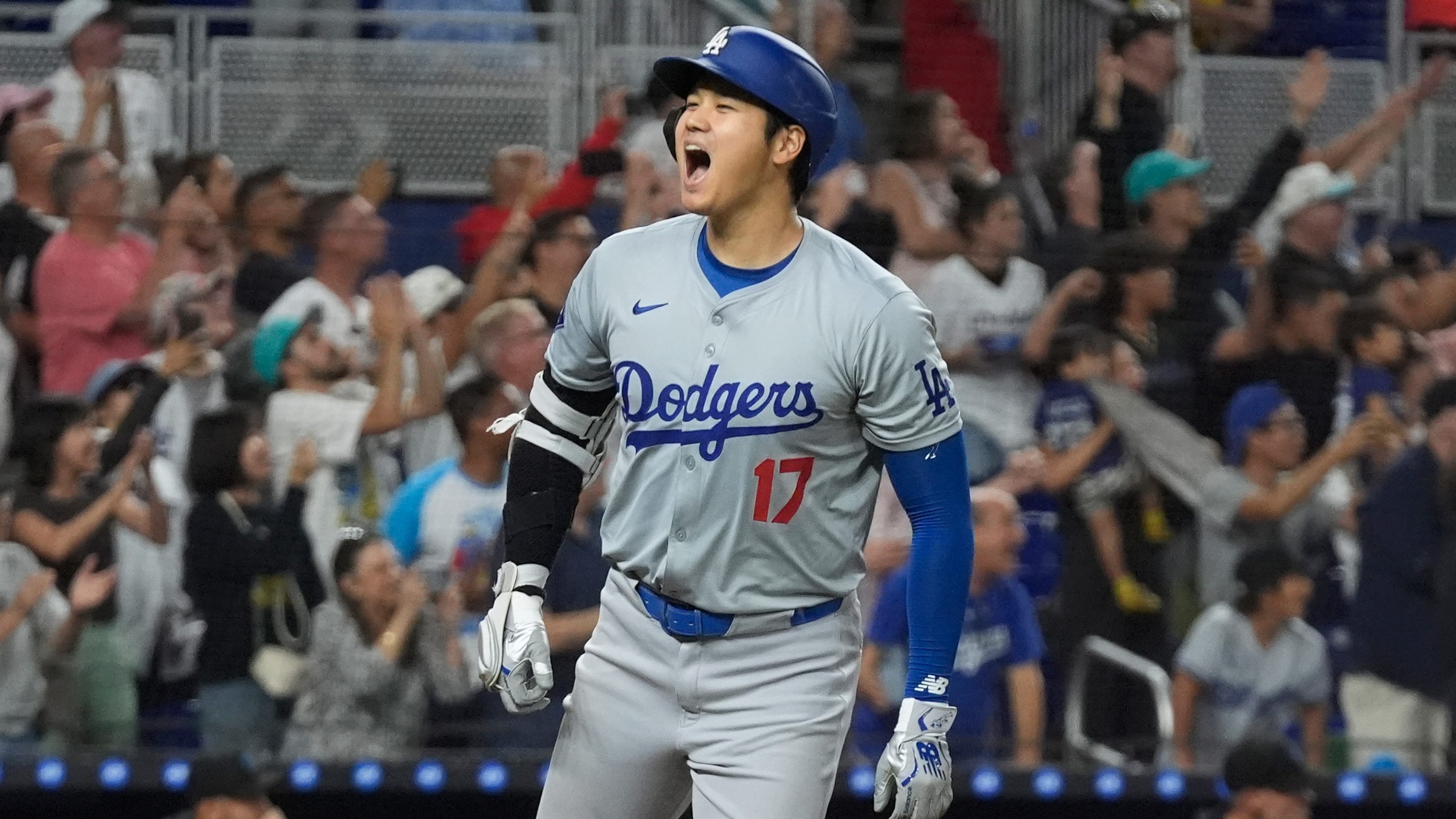 Shohei Ohtani yells in celebration toward his dugout after launching a home run