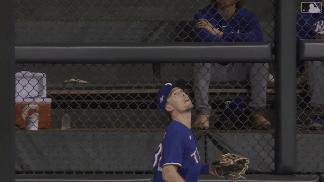 An animated gif of Evan Carter making a leaping catch at the fence