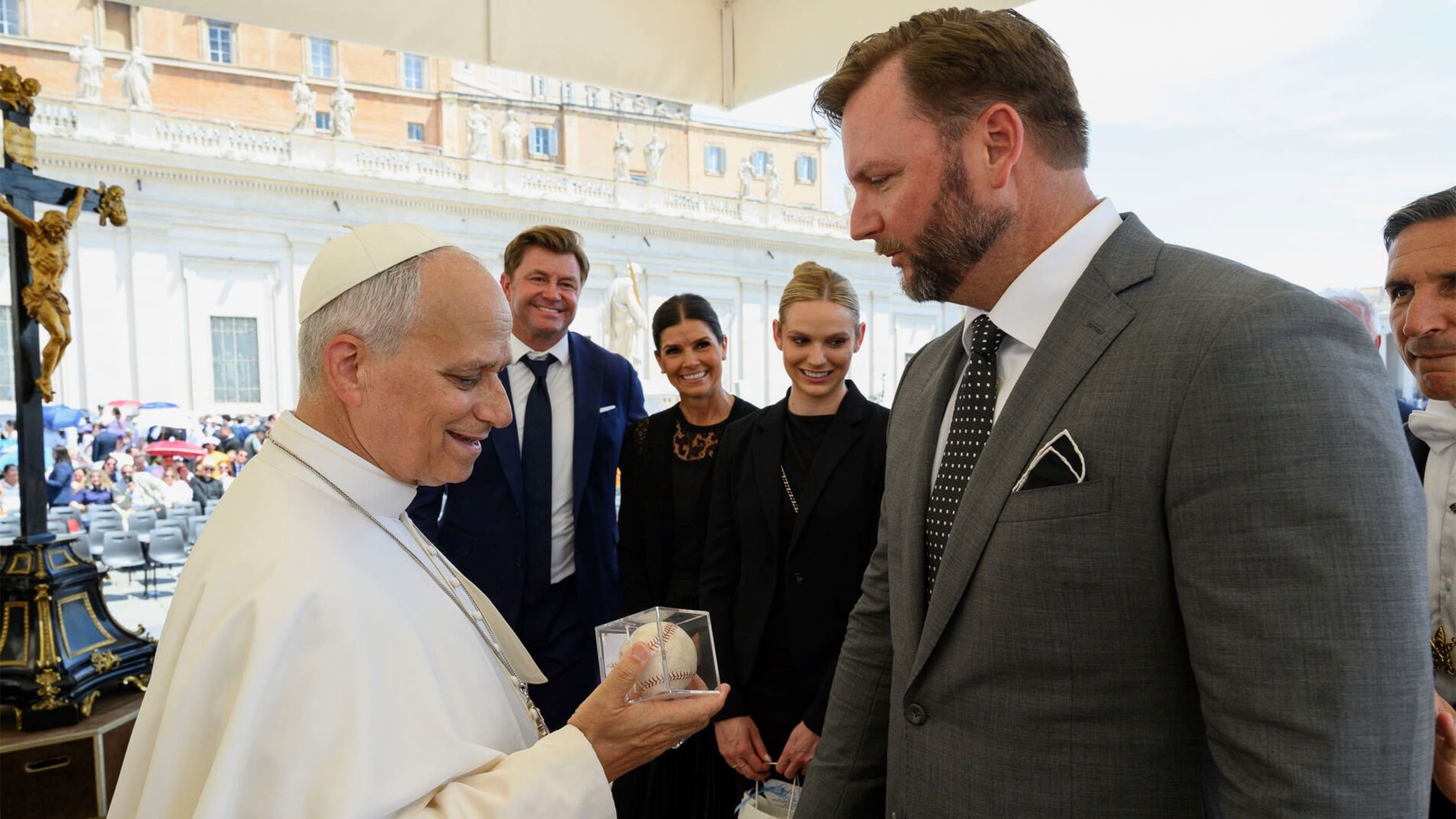 Pope Leo XIV looks at a baseball given to him by A.J. Pierzynski