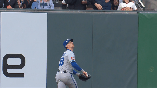 An animated gif of Cavan Biggio making a leaping catch just before crashing into the outfield wall