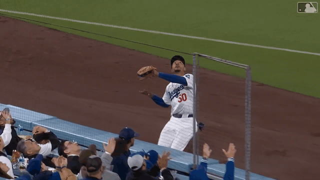 Mookie Betts twists to make a catch against the net