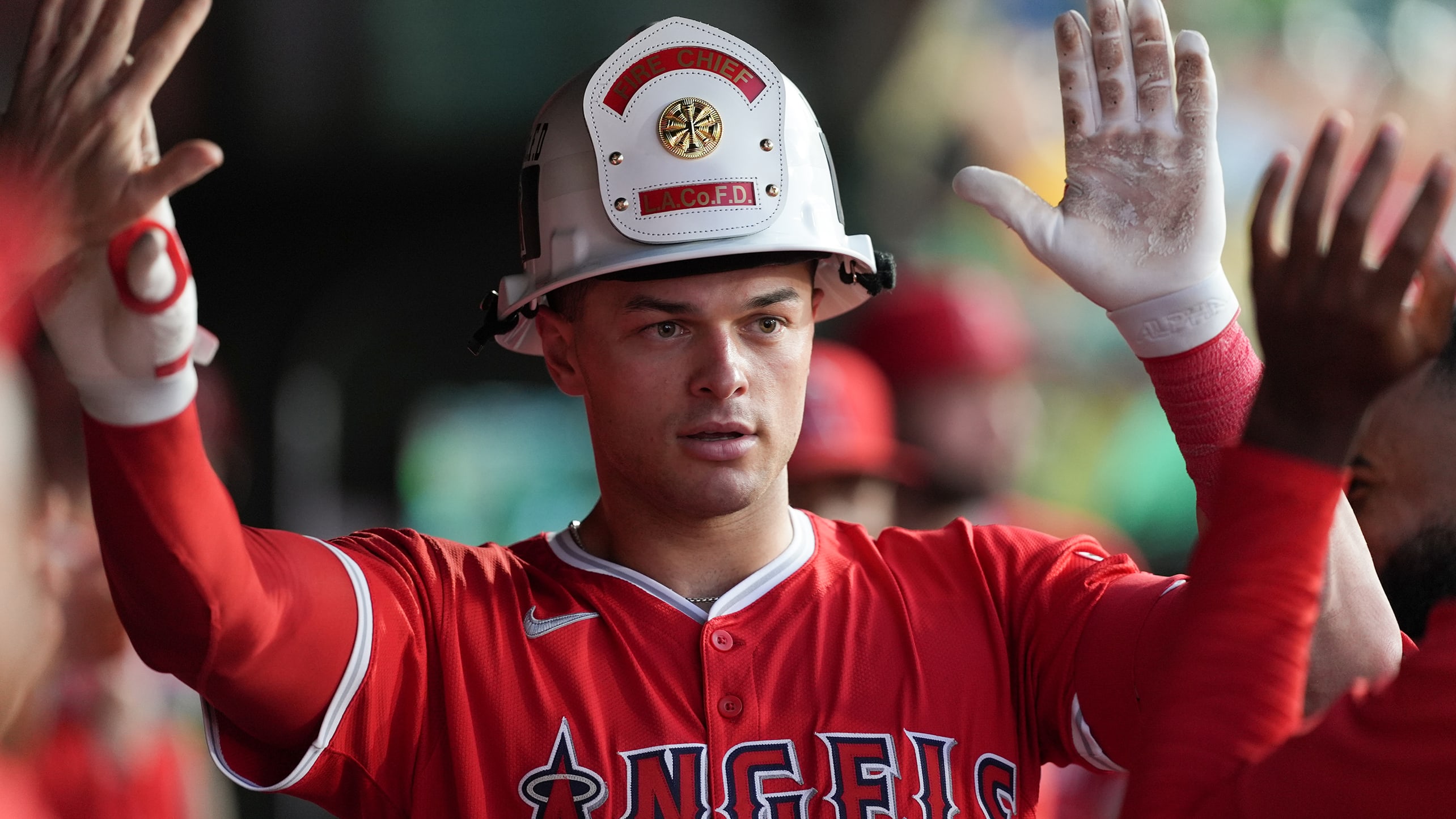 Logan O'Hoppe in an L.A. fire helmet high-fives teammates