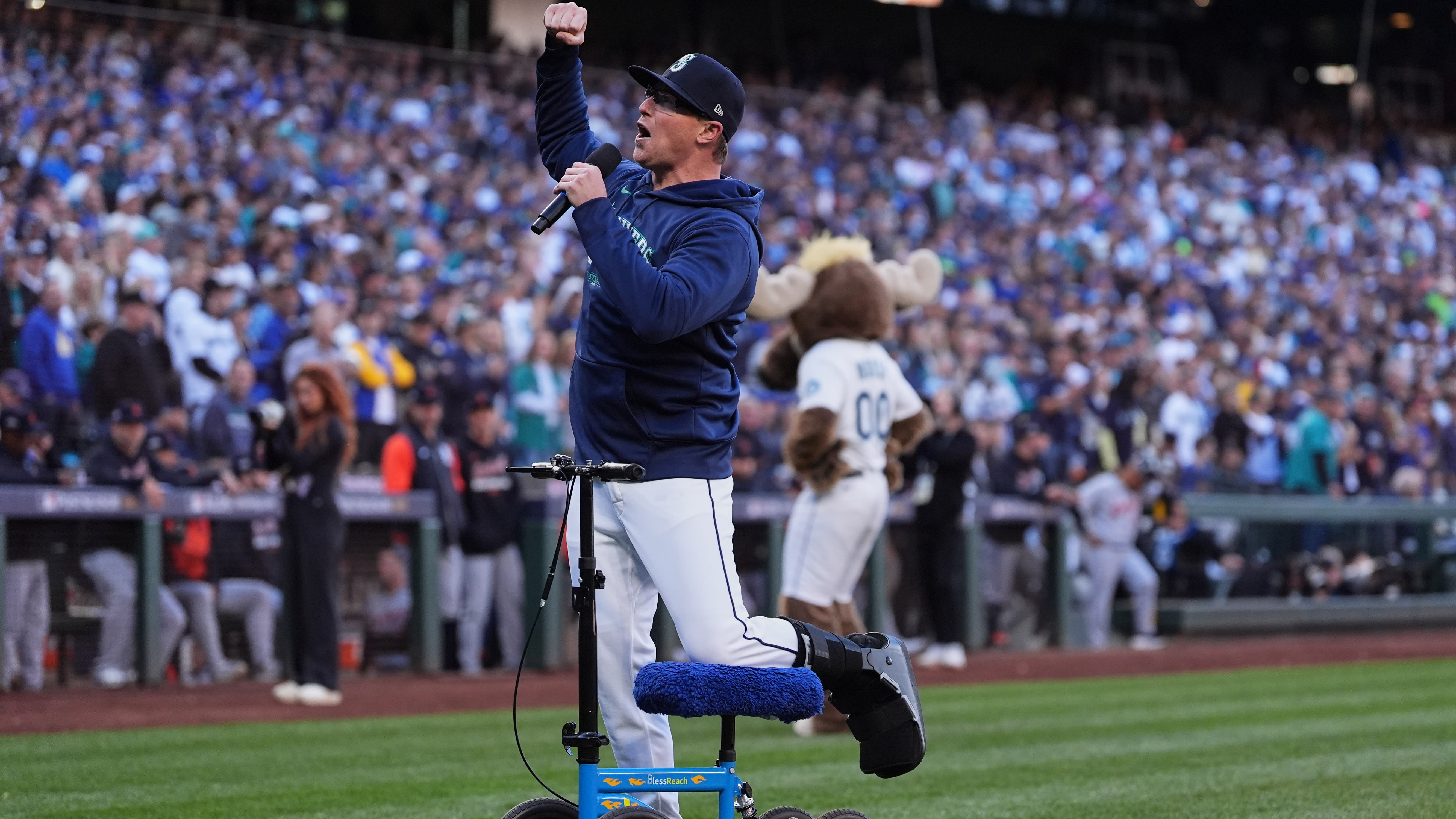 Mariners pitcher Trent Thornton stands on the field with his left leg propped on a scooter