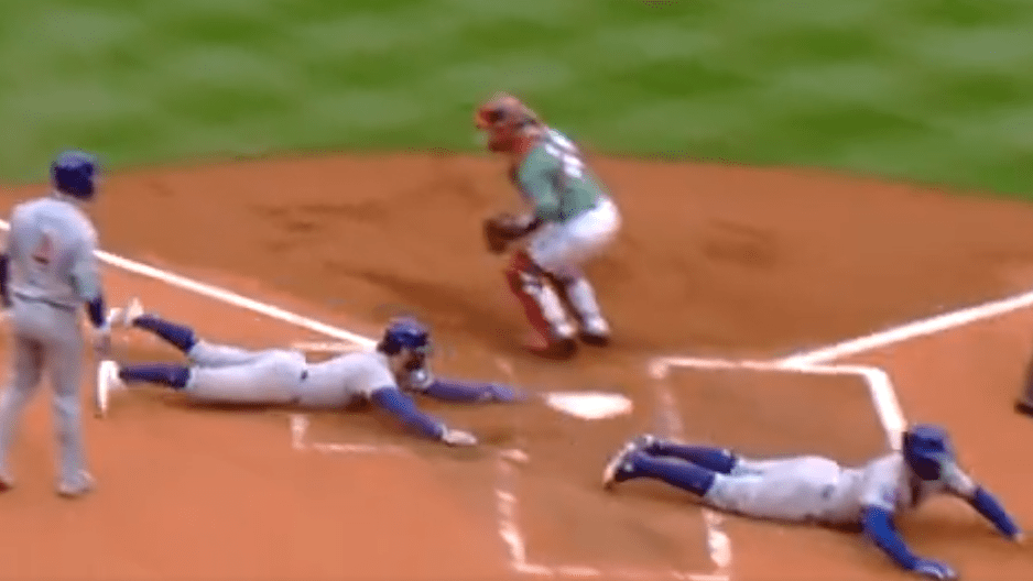 One Cubs runner slides into home plate just after a runner before him