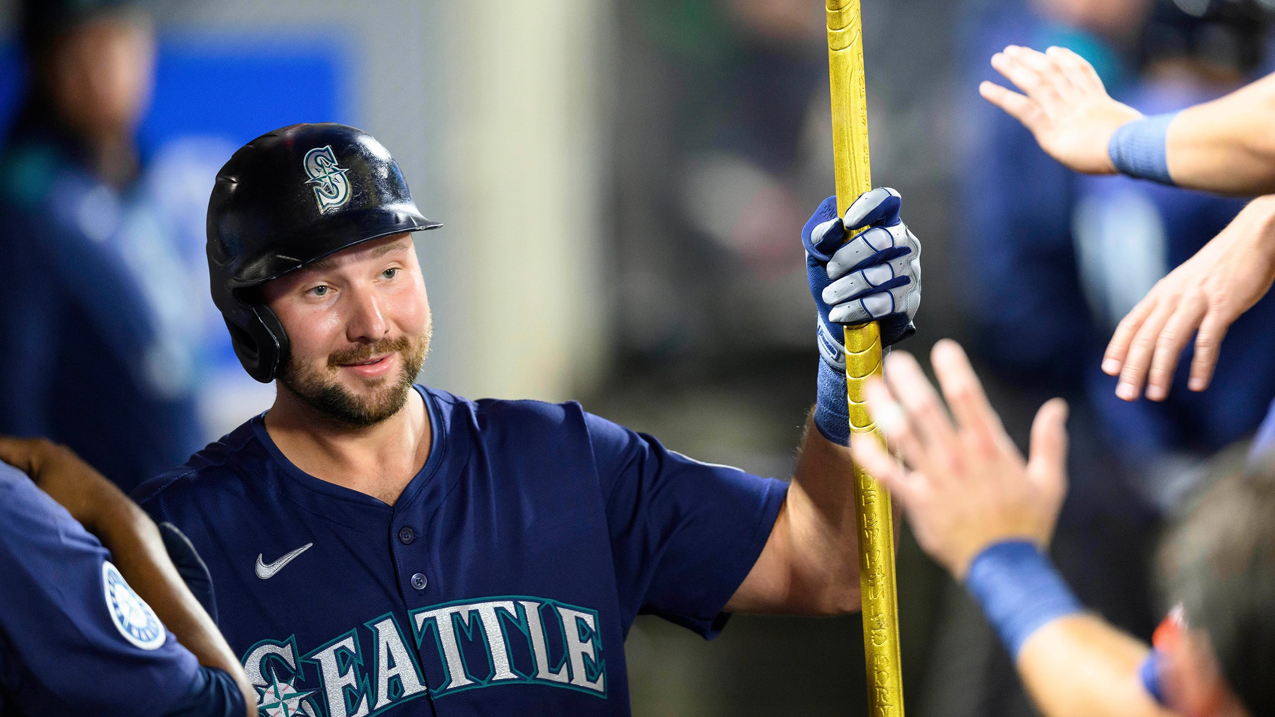 Cal Raleigh holds a trident in the dugout after hitting his 40th home run