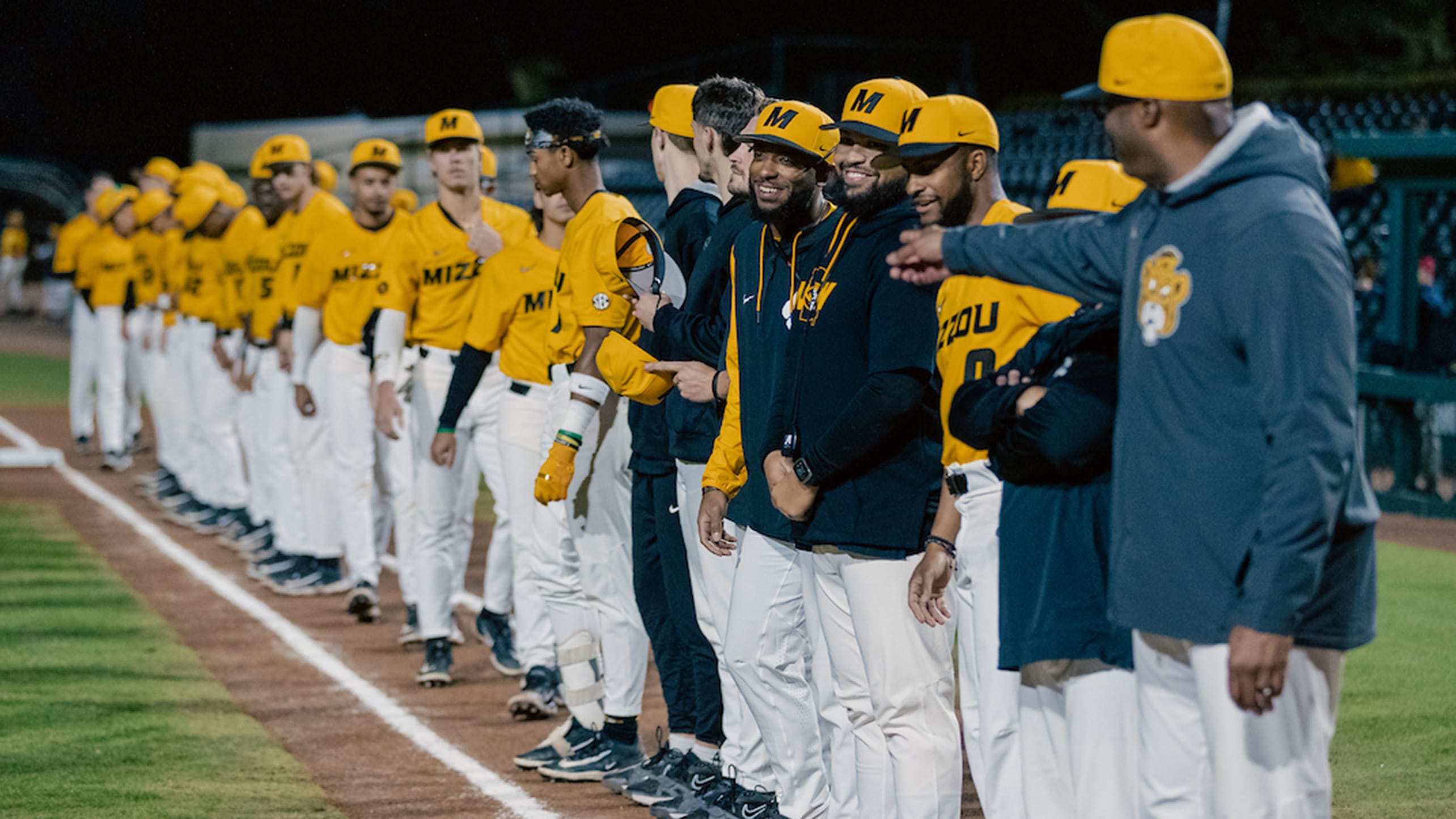 Missouri players and coaches line the field