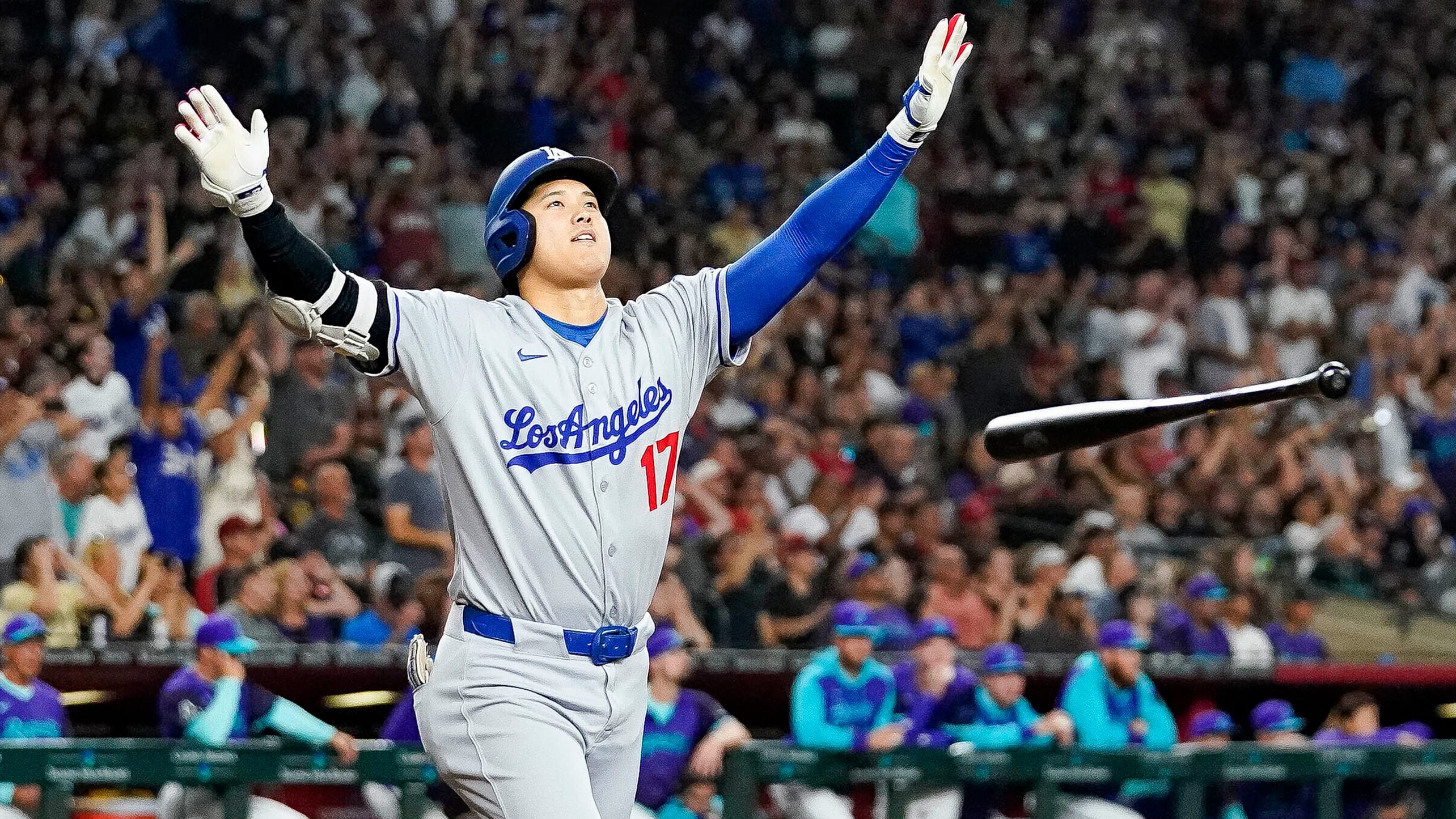 Shohei Ohtani raises his arms after tossing his bat following his tiebreaking homer