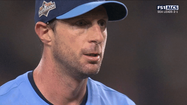 An animated gif of an animated Max Scherzer talking to manager John Schneider on the mound