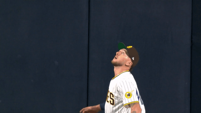 An animated gif of Jackson Merrill reaching way over the wall to rob a home run