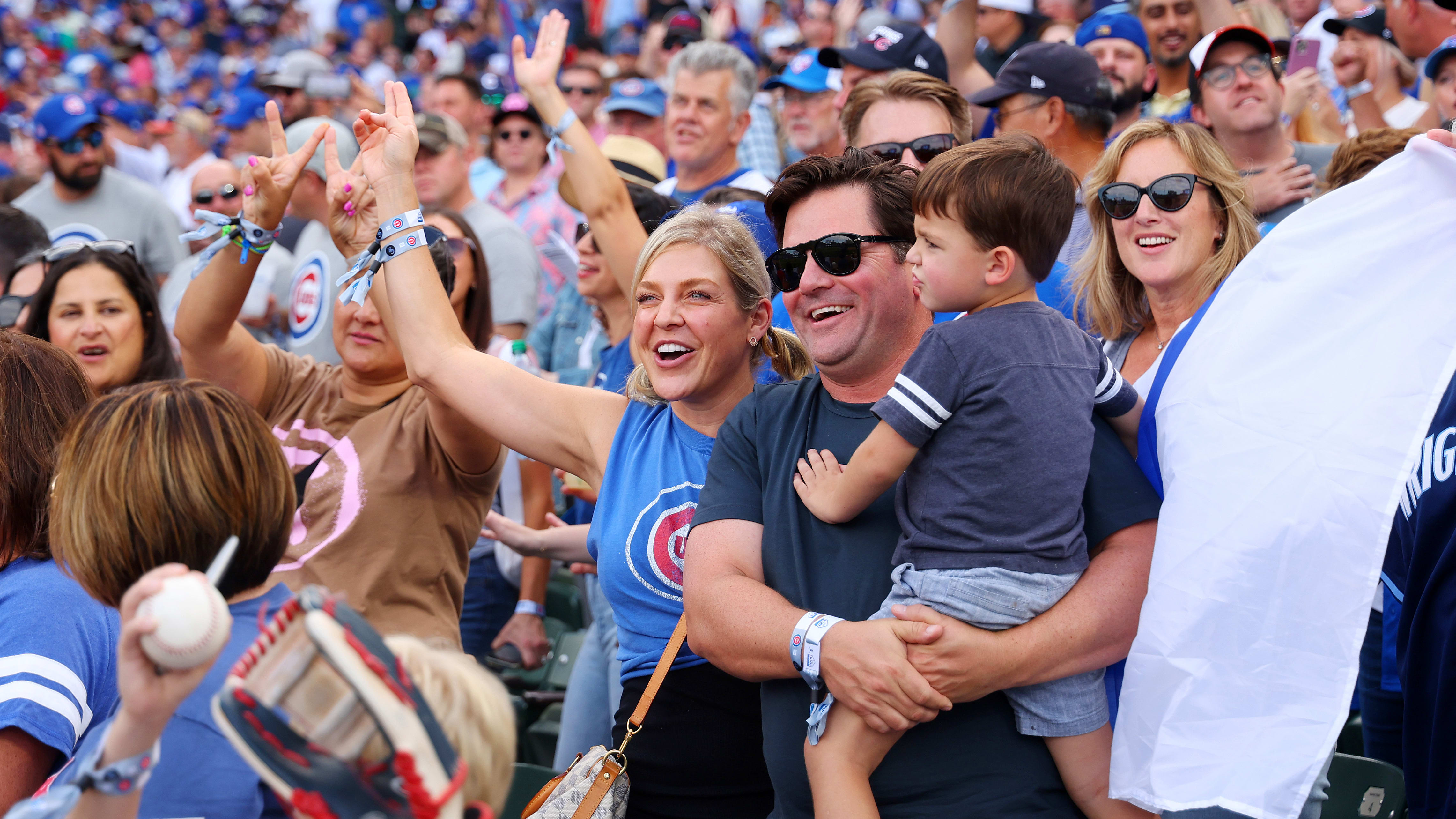 A group of baseball fans in the stands watching a game