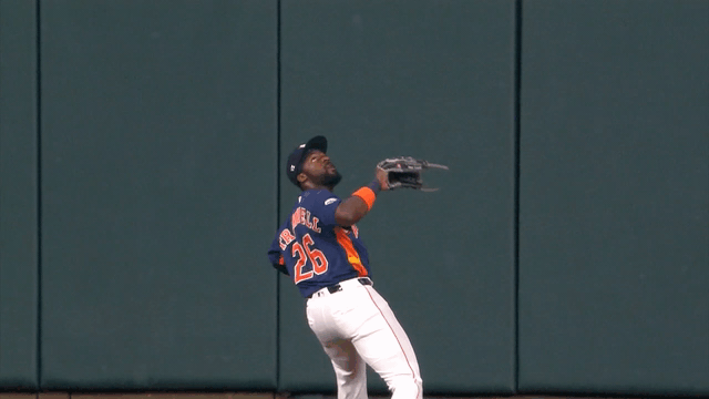 An animated gif of Taylor Trammell making a leaping, twisting catch in front of the wall