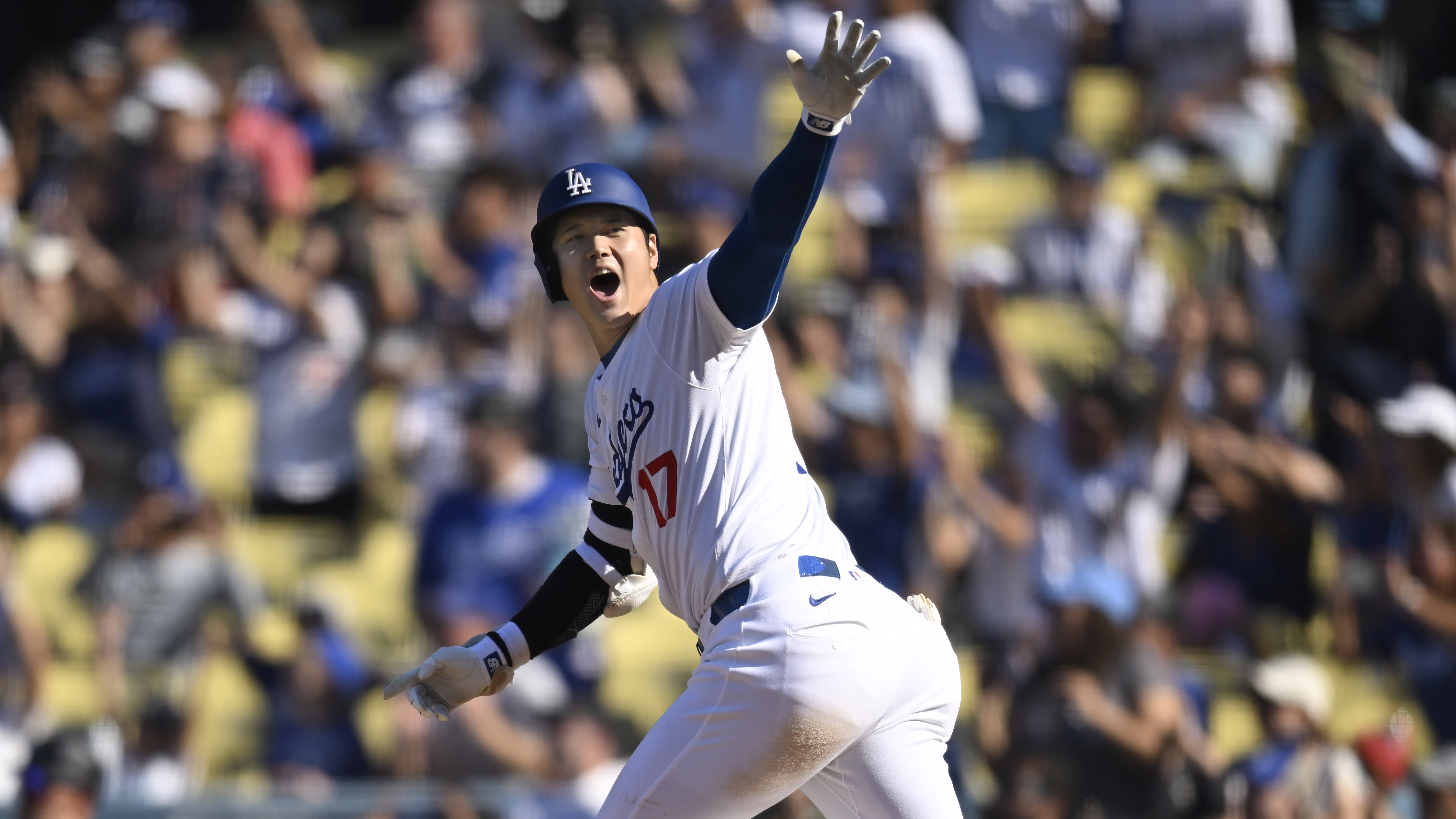 Shohei Ohtani waves as he rounds the bases